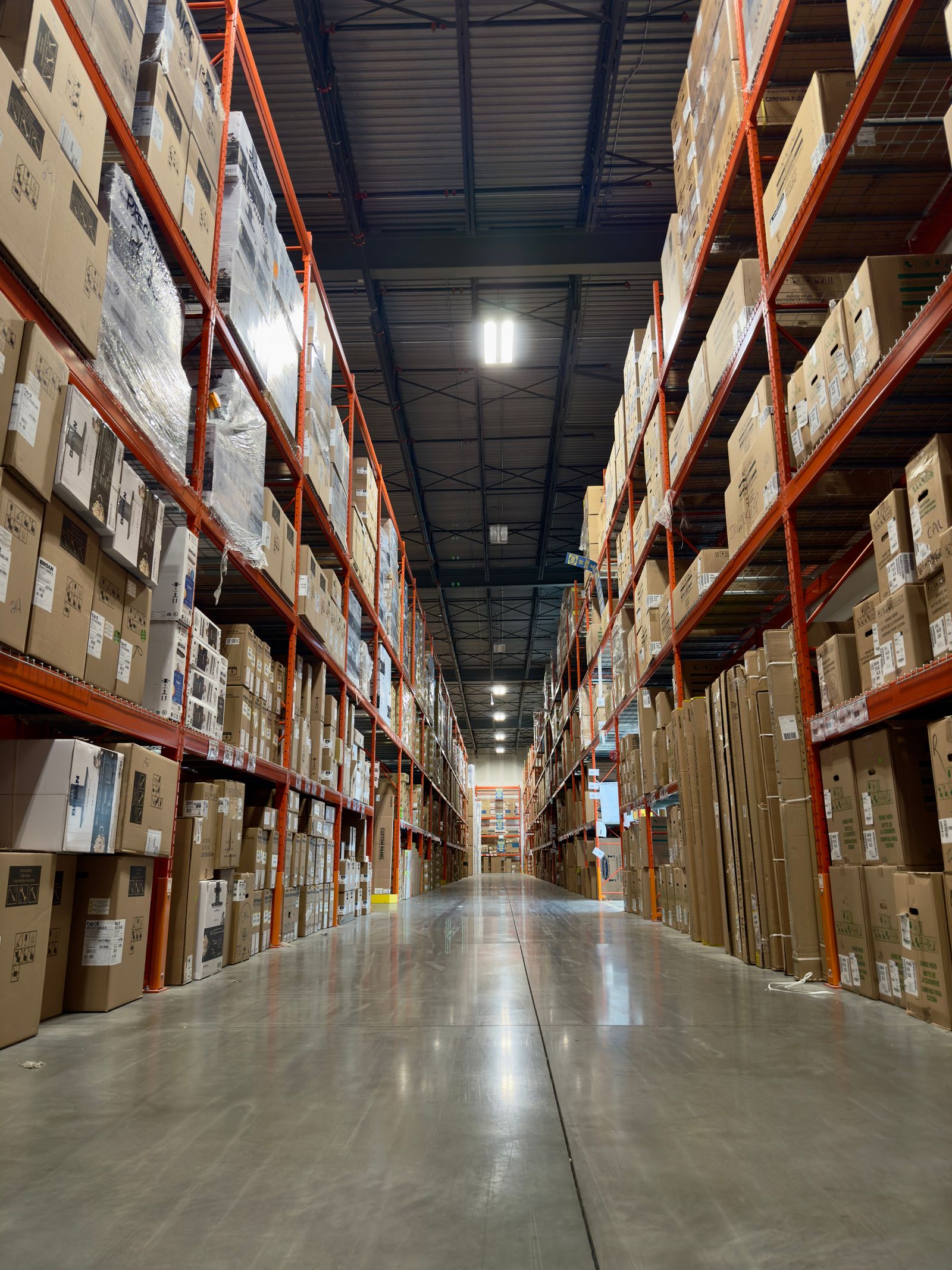 A long aisle of tall pallet racking in a distribution warehouse — illustrative photography